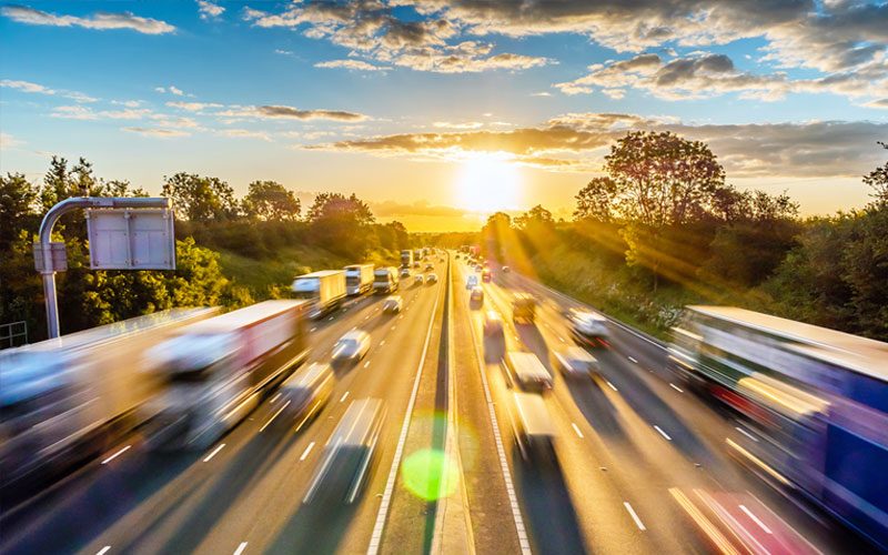 Highway traffic at sunrise powered by sustainable lead batteries. Blurred highway traffic and a sunrise demonstrating the essential nature of lead batteries to power our lives.