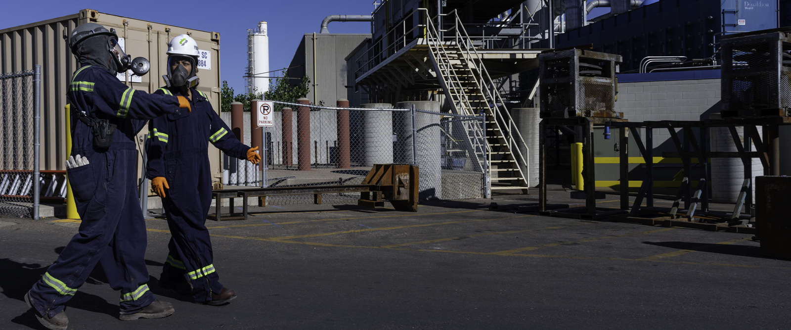 Lead battery recycling employees walking outside of the recycling plant. Lead battery recycling employees walking outside of the recycling plant.
