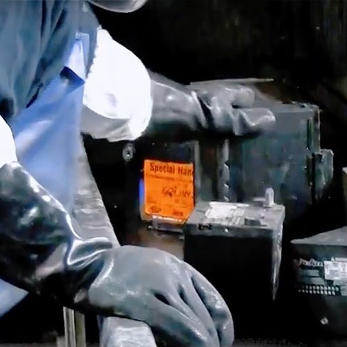 Lead battery worker sorting lead batteries to identify and remove lithium batteries from the recycling stream.