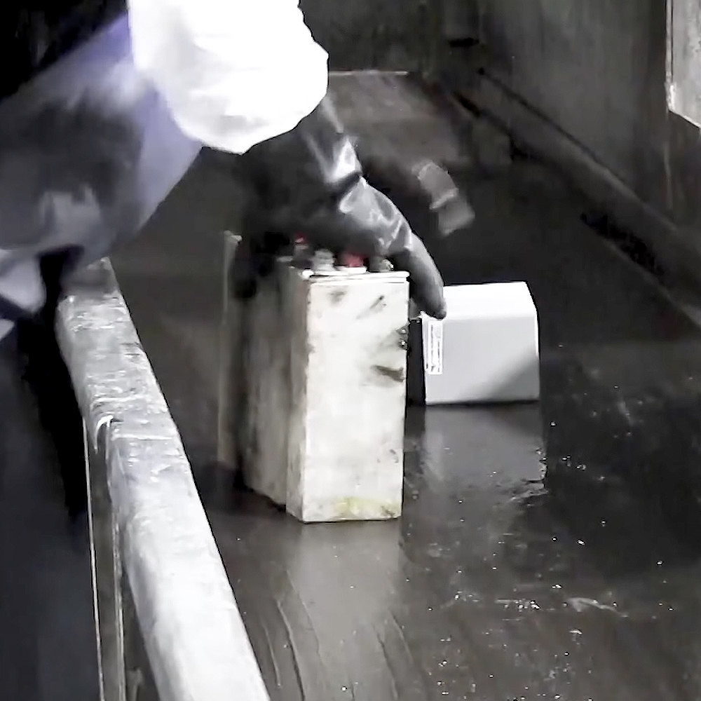Worker identifying and removing a lithium battery from the lead battery recycling stream.