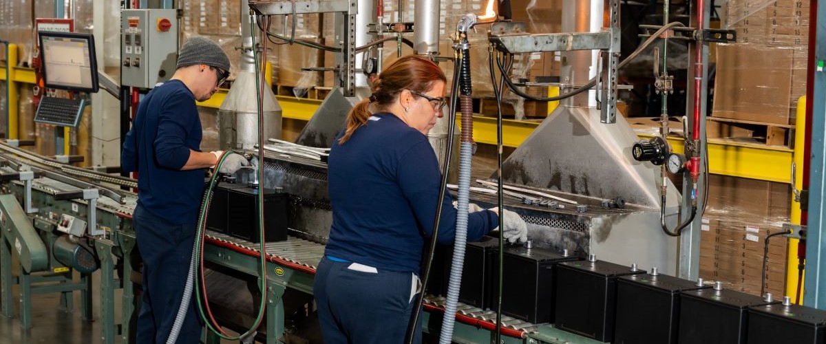 East Penn Manufacturing employees working on a lead battery production line, supporting American battery manufacturing and recycling.